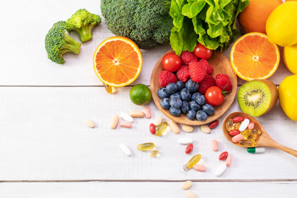 Uma vista superior de frutas e legumes frescos com medicamentos diferentes em uma colher de pau