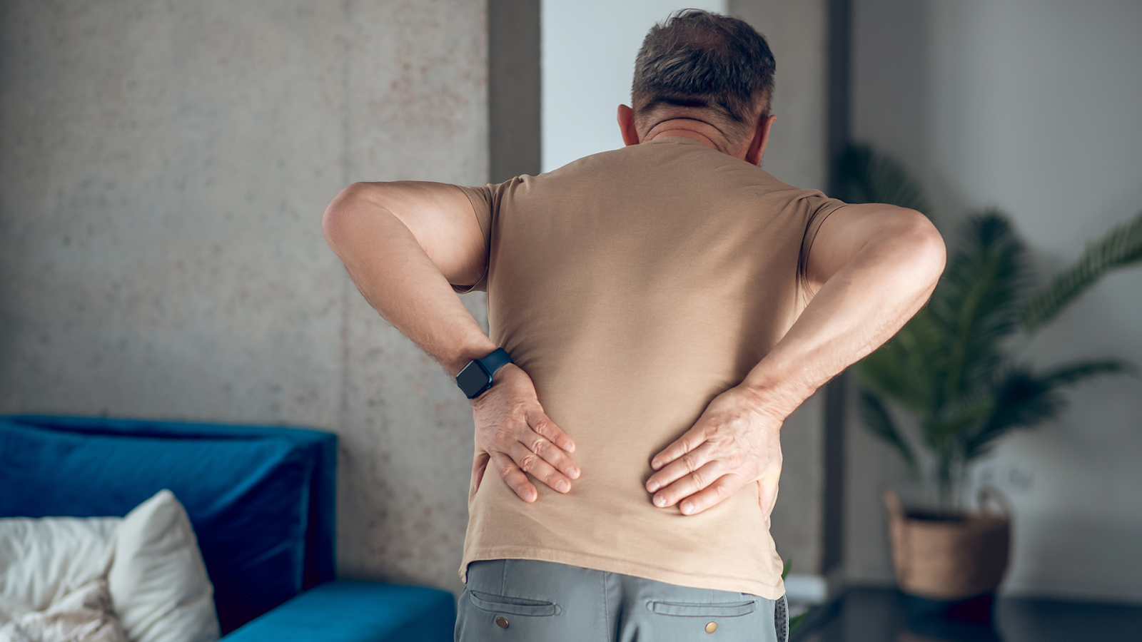homem de meia idade de costas apresentando dor lombar