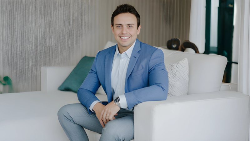 dr. fábio vieira, médico especialista em dor na coluna, sentado em um sofá branco